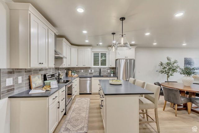 909 W 1180 N, Pleasant Grove, UT 84062 - kitchen with appliances with stainless steel finishes, dark countertops, a sink, a kitchen breakfast bar, and recessed lighting