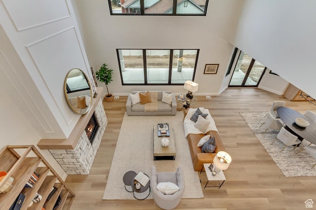 909 W 1180 N, Pleasant Grove, UT 84062 - living area with a towering ceiling, wood finished floors, baseboards, and a warm lit fireplace