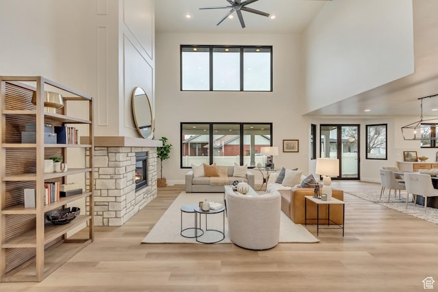 909 W 1180 N, Pleasant Grove, UT 84062 - living area featuring a towering ceiling, light wood-style floors, a stone fireplace, a ceiling fan, and a chandelier