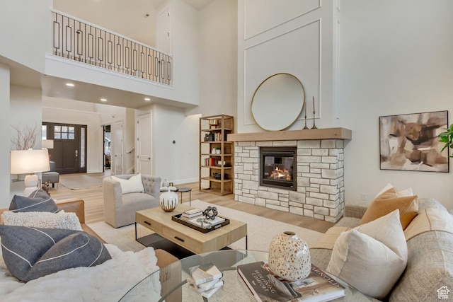 909 W 1180 N, Pleasant Grove, UT 84062 - living area with a towering ceiling, light wood-type flooring, a stone fireplace, and baseboards