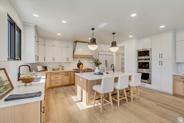 909 W 1180 N, Pleasant Grove, UT 84062 - kitchen with custom exhaust hood, light countertops, built in appliances, light wood-style floors, and a sink