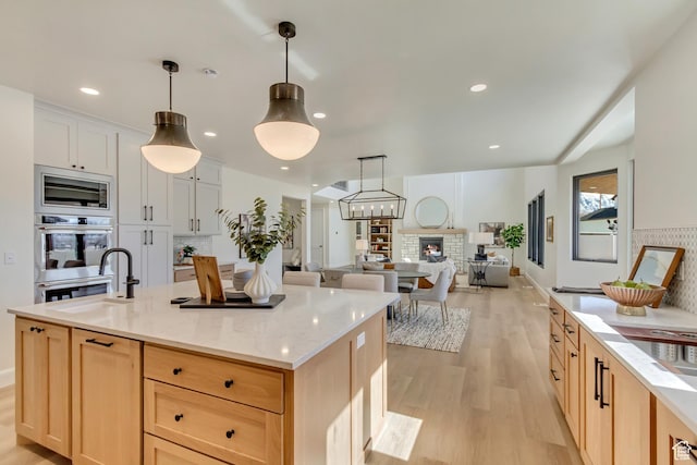 909 W 1180 N, Pleasant Grove, UT 84062 - kitchen featuring a sink, light wood-style flooring, stainless steel microwave, tasteful backsplash, and light stone counters