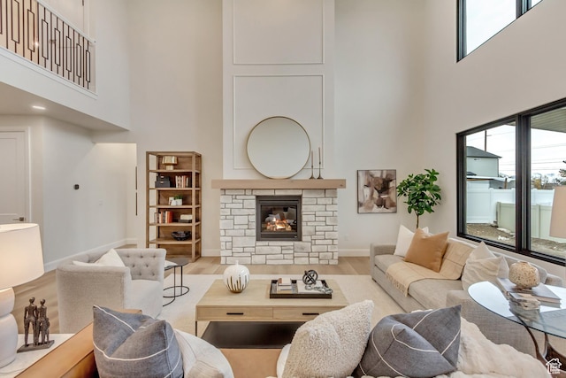 living room with wood finished floors, plenty of natural light, a fireplace, and baseboards