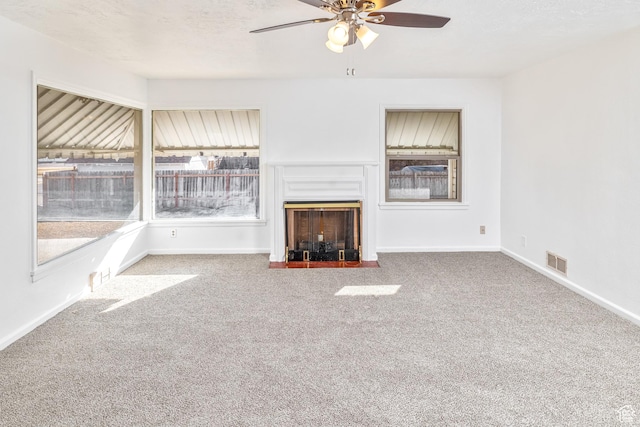 unfurnished living room featuring carpet floors, a textured ceiling, and ceiling fan
