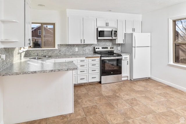 kitchen with white cabinetry, stainless steel appliances, sink, and backsplash