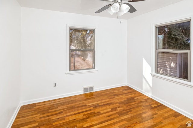 empty room with hardwood / wood-style floors and ceiling fan