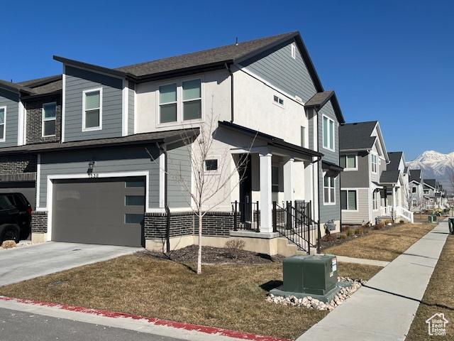 view of front of property featuring a residential view, concrete driveway, and a garage