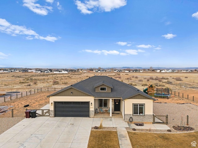 2418 W 4975 N, Cedar City, UT 84721 - view of front of home featuring a playground, a garage, a rural view, and a trampoline