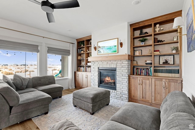 2418 W 4975 N, Cedar City, UT 84721 - living room with built in shelves, ceiling fan, a brick fireplace, and light hardwood / wood-style flooring