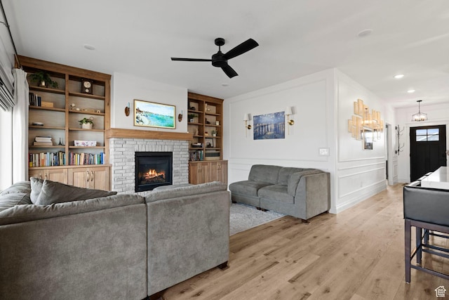 2418 W 4975 N, Cedar City, UT 84721 - living room with ceiling fan, a brick fireplace, built in features, and light wood-type flooring