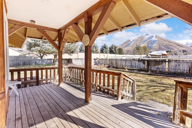 wooden terrace with a mountain view and a yard
