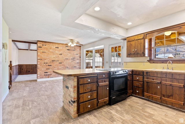kitchen with ceiling fan, kitchen peninsula, light wood-type flooring, and black / electric stove