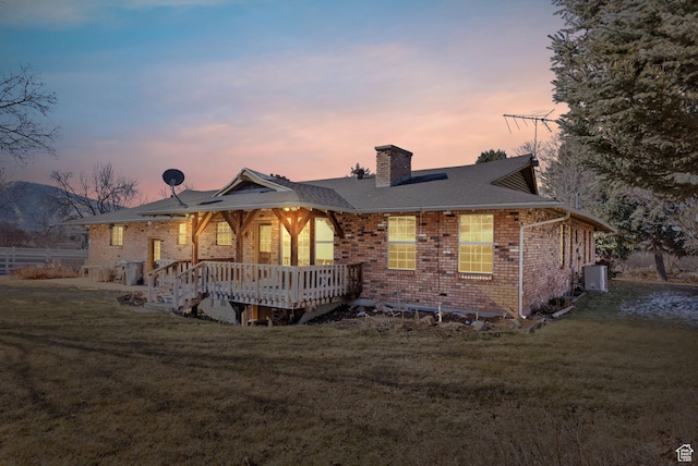 view of front of property featuring a wooden deck and a yard