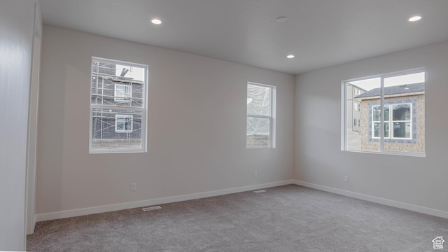 empty room featuring plenty of natural light, recessed lighting, and carpet flooring