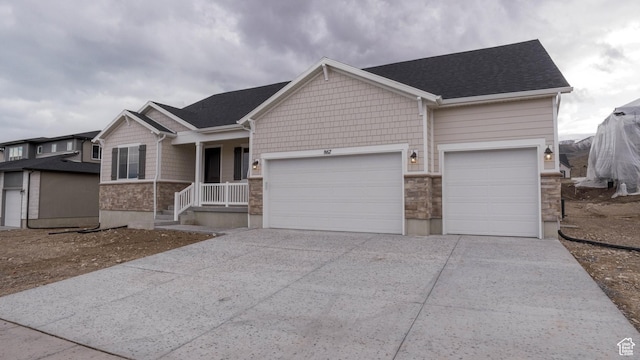 view of front of house with stone siding, a garage, and concrete driveway