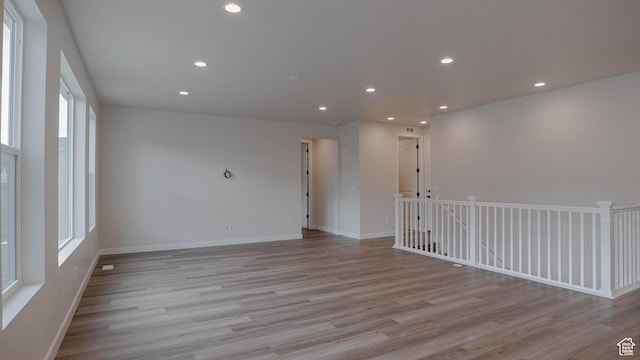 unfurnished room with wood finished floors, baseboards, and recessed lighting