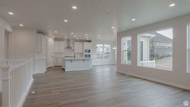 unfurnished living room featuring baseboards, light wood-style flooring, and recessed lighting