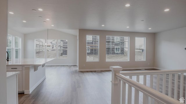 living room featuring a wealth of natural light, wood finished floors, recessed lighting, and a chandelier