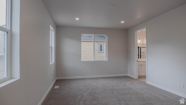 empty room with light carpet, baseboards, and recessed lighting