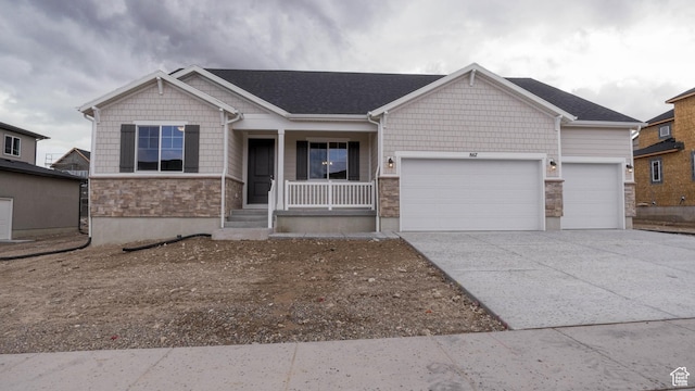 craftsman-style home with driveway, an attached garage, stone siding, and a porch