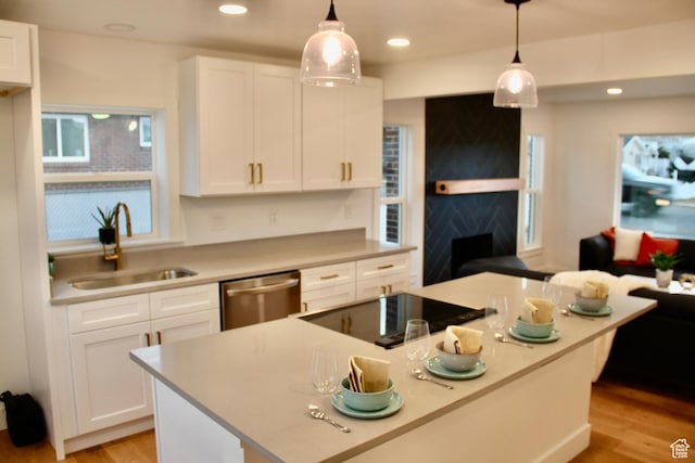 kitchen featuring sink, white cabinetry, a center island, dishwasher, and pendant lighting