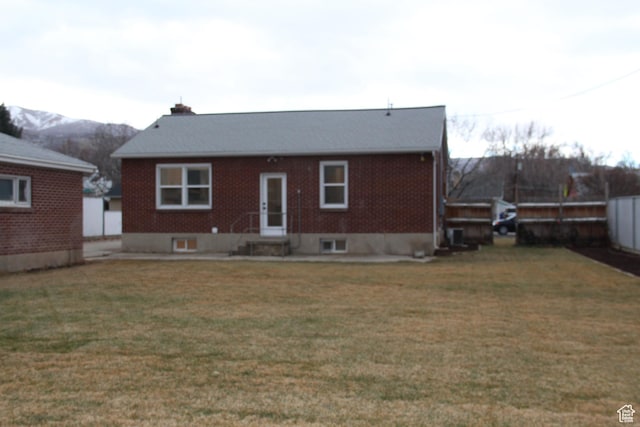 back of property with a yard and a mountain view