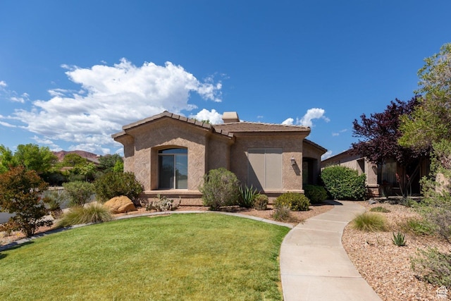view of front of home with stucco siding, a front lawn, and a tiled roof