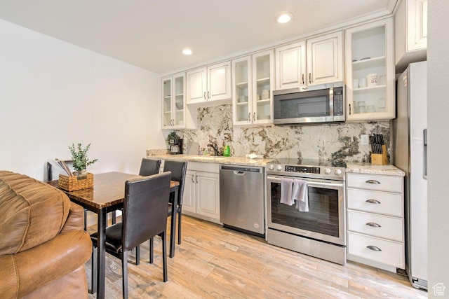 286 W Eagles Roost St Unit D-101, Brian Head, UT 84719 - kitchen featuring white cabinets, appliances with stainless steel finishes, backsplash, and light hardwood / wood-style flooring
