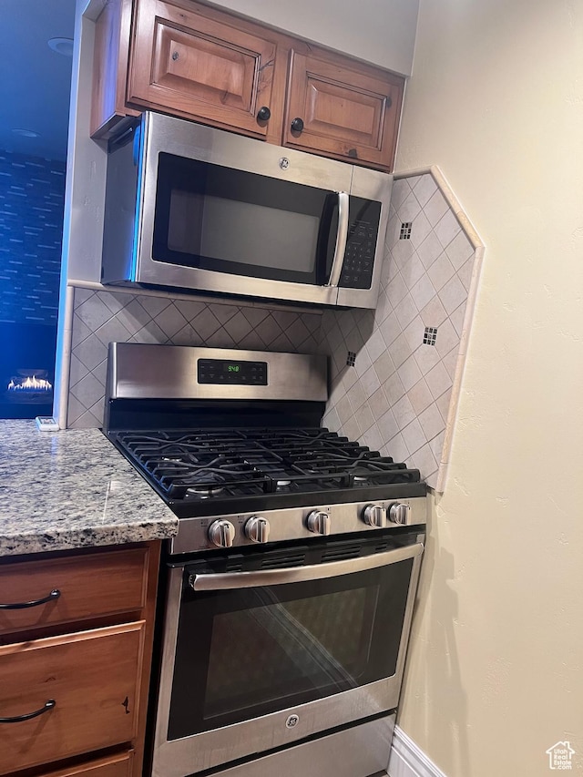 5676 Meadow Ln Unit 123, Ogden, UT 84403 - kitchen featuring stainless steel appliances, stone countertops, and backsplash