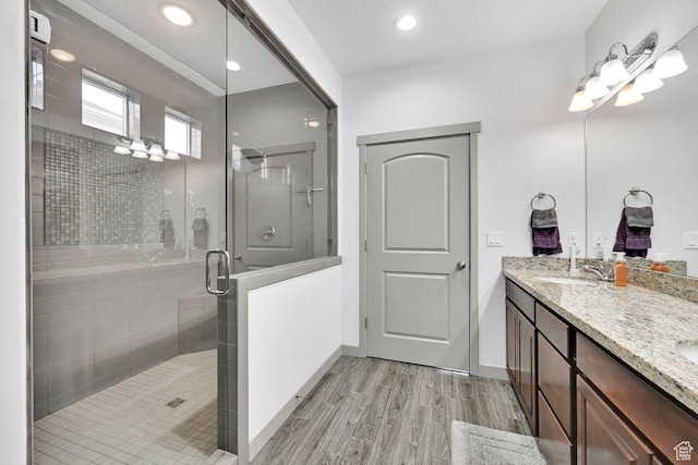 111 S 2300 W, Kaysville, UT 84037 - bathroom featuring a sink, double vanity, baseboards, a shower stall, and wood finished floors