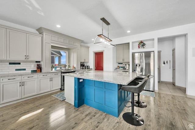 111 S 2300 W, Kaysville, UT 84037 - kitchen featuring a kitchen breakfast bar, backsplash, stainless steel appliances, and recessed lighting