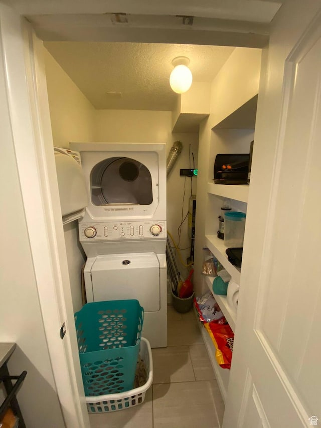 127 Mason Ln, North Salt Lake, UT 84054 - clothes washing area featuring stacked washer and clothes dryer, tile patterned floors, and a textured ceiling