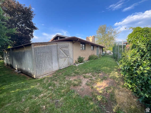 1127 W 4250 S, Riverdale, UT 84405 - view of property exterior with a chimney, brick siding, and a storage shed