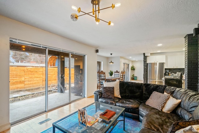 1078 Sumac Dr, Logan, UT 84321 - living room with light wood-type flooring, a textured ceiling, and a chandelier