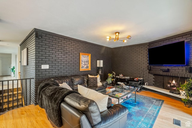 1078 Sumac Dr, Logan, UT 84321 - living room featuring brick wall, a fireplace, and light hardwood / wood-style flooring