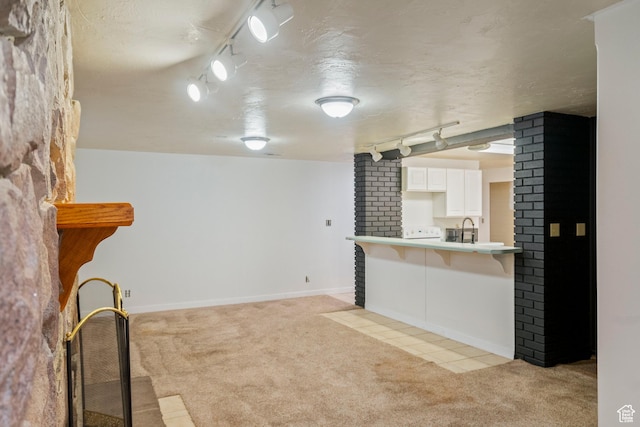 1078 Sumac Dr, Logan, UT 84321 - interior space featuring rail lighting, sink, light carpet, and a textured ceiling