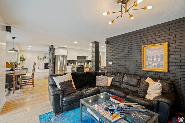 1078 Sumac Dr, Logan, UT 84321 - living room featuring light hardwood / wood-style floors, a chandelier, and brick wall