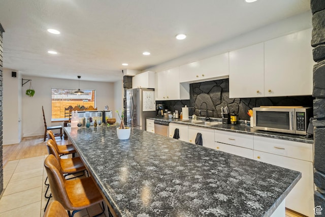 1078 Sumac Dr, Logan, UT 84321 - kitchen with appliances with stainless steel finishes, pendant lighting, white cabinetry, sink, and a large island