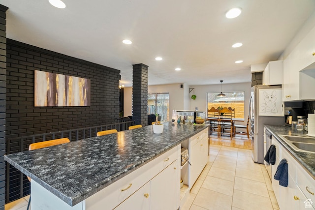 1078 Sumac Dr, Logan, UT 84321 - kitchen with a kitchen island, pendant lighting, white cabinetry, decorative backsplash, and light tile patterned floors
