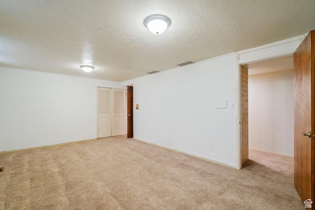 1078 Sumac Dr, Logan, UT 84321 - basement featuring brick wall, light colored carpet, and a textured ceiling