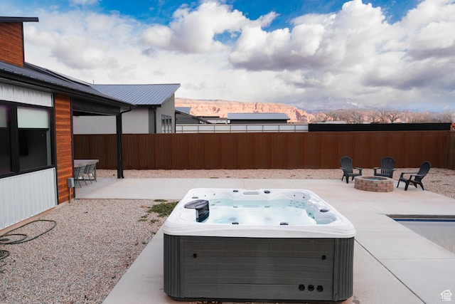 145 Crimson Cliffs Dr, Moab, UT 84532 - view of patio / terrace featuring an outdoor fire pit, a hot tub, and a mountain view