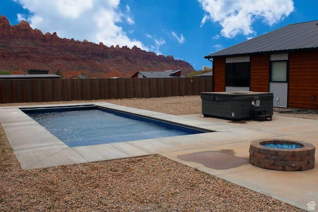 145 Crimson Cliffs Dr, Moab, UT 84532 - view of swimming pool with an outdoor fire pit, a hot tub, a mountain view, and a patio area