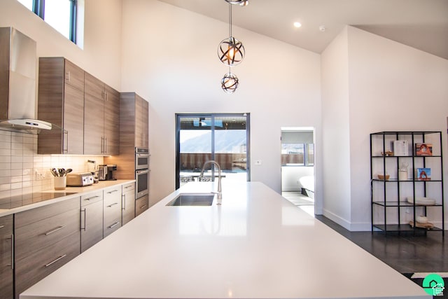 145 Crimson Cliffs Dr, Moab, UT 84532 - kitchen with sink, black electric cooktop, pendant lighting, a towering ceiling, and wall chimney range hood