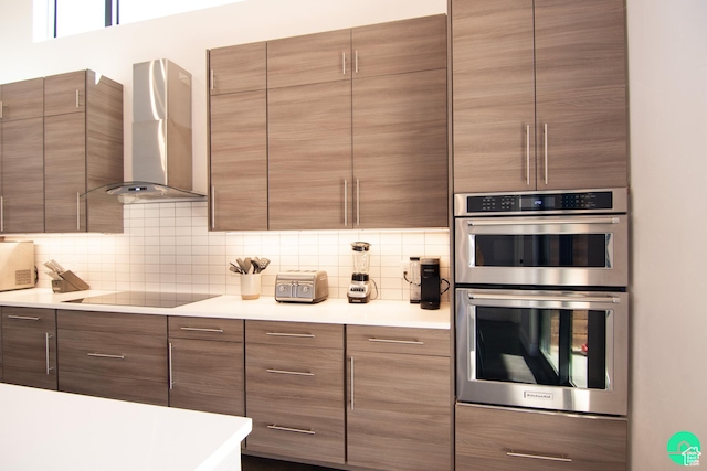 145 Crimson Cliffs Dr, Moab, UT 84532 - kitchen with wall chimney range hood, tasteful backsplash, stainless steel double oven, and black electric cooktop