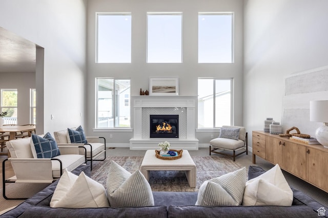 7288 W Hall Crossing Dr S, Herriman, UT 84096 - living area featuring carpet flooring, a towering ceiling, a glass covered fireplace, and plenty of natural light