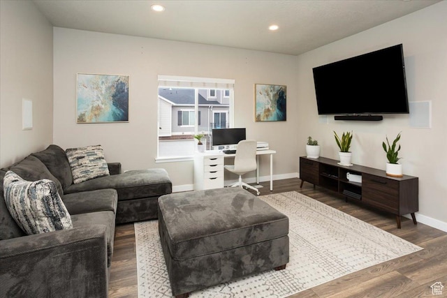 living area with baseboards, wood finished floors, and recessed lighting