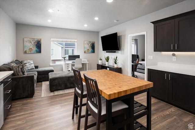 dining space with dark wood-style floors, recessed lighting, and a textured ceiling