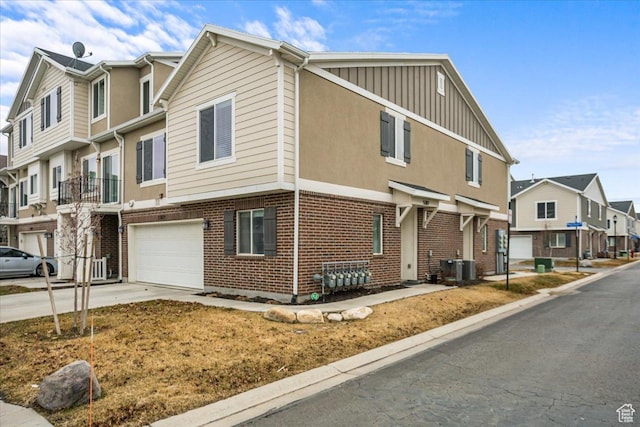 view of front of property featuring a garage, brick siding, board and batten siding, a residential view, and driveway