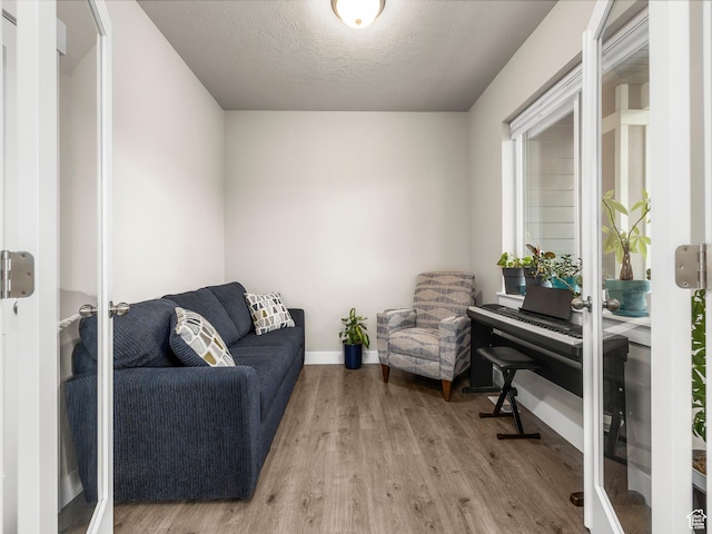 1352 E Abigail Ln, Eagle Mountain, UT 84005 - living area with french doors, a textured ceiling, and light wood-type flooring