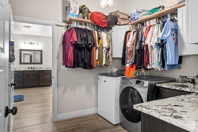 711 W Main St, Enterprise, UT 84725 - clothes washing area with cabinets, washing machine and dryer, sink, and light hardwood / wood-style floors